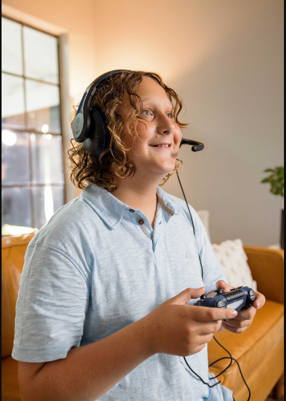 a boy wearing headphones and holding a game controller