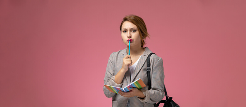 a woman holding a pen in her mouth