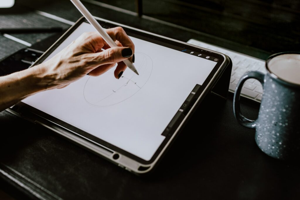 a hand holding a stylus on a white screen