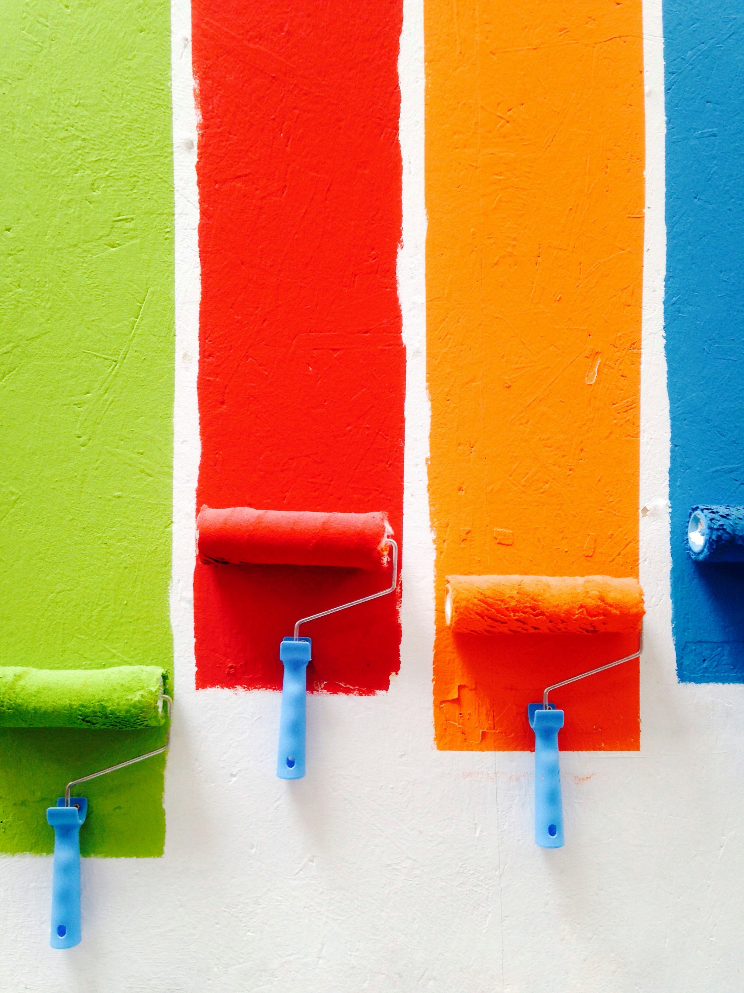 a row of paint rollers on a wall