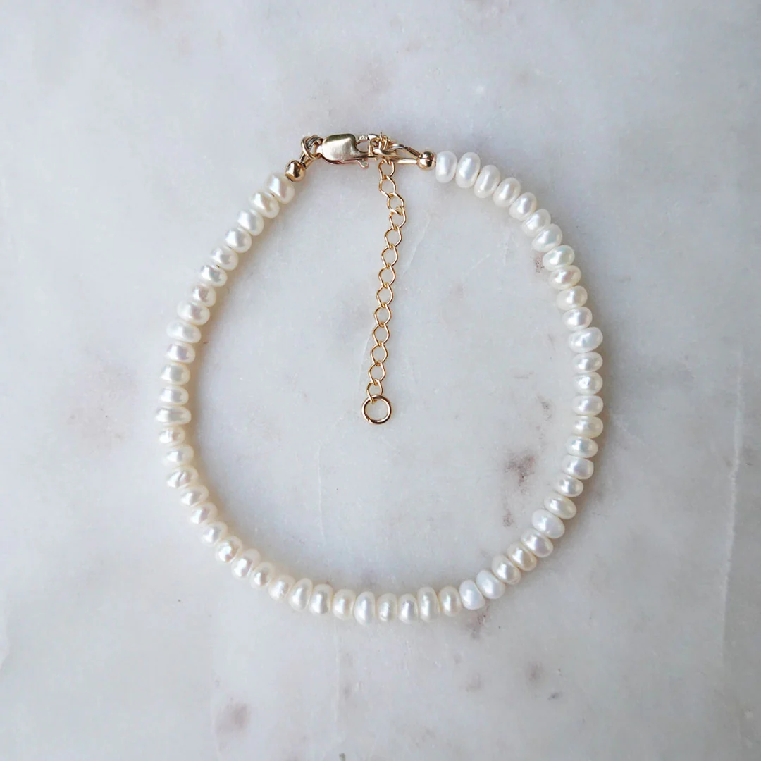 a pearl bracelet on a marble surface