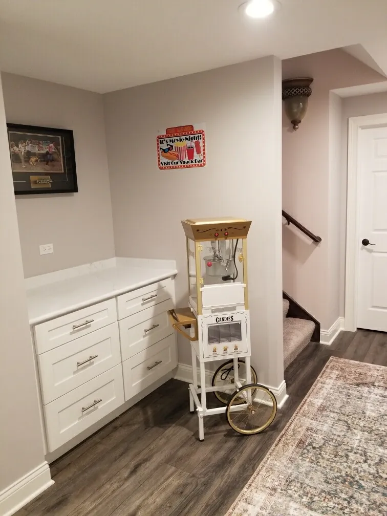 a room with a machine and white cabinets