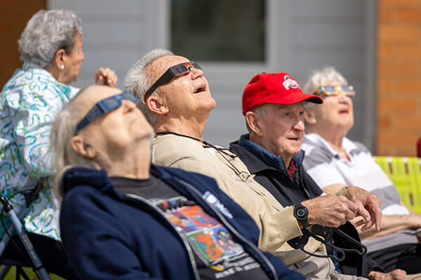 a group of people sitting in a row wearing sunglasses