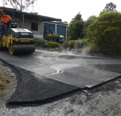 a man on a roller compacting asphalt