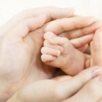 a close-up of hands holding a baby's foot