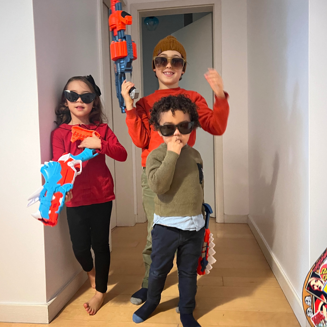a group of kids wearing sunglasses and holding toy guns