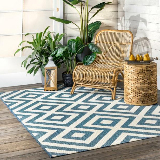 a wicker chair and a rug on a patio