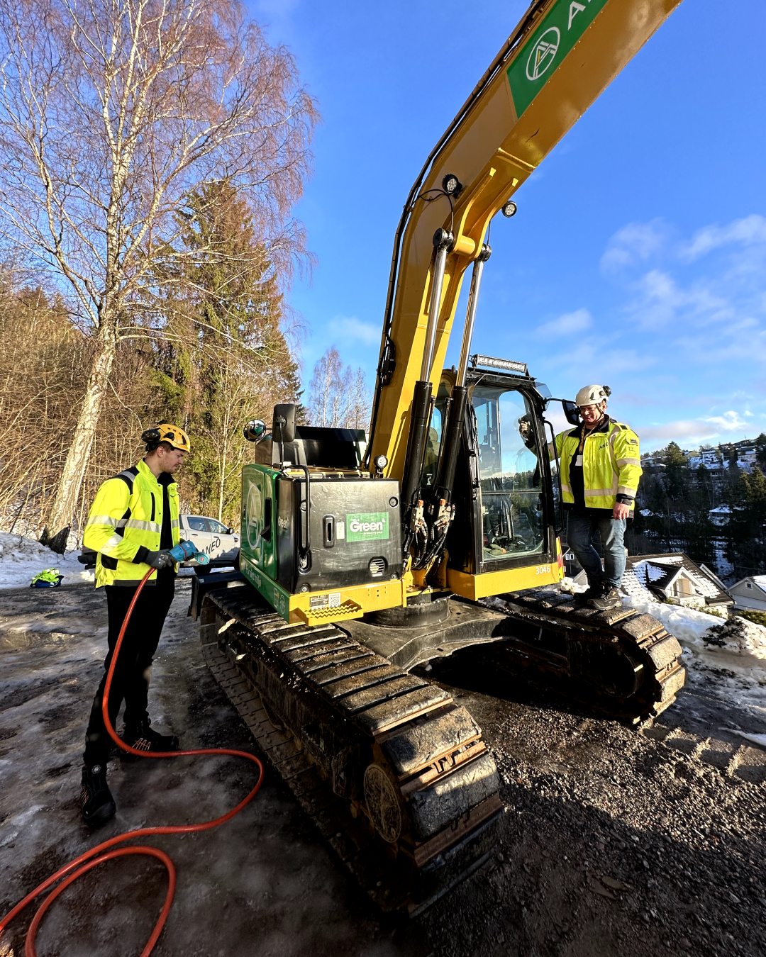 a group of men standing next to a construction vehicle