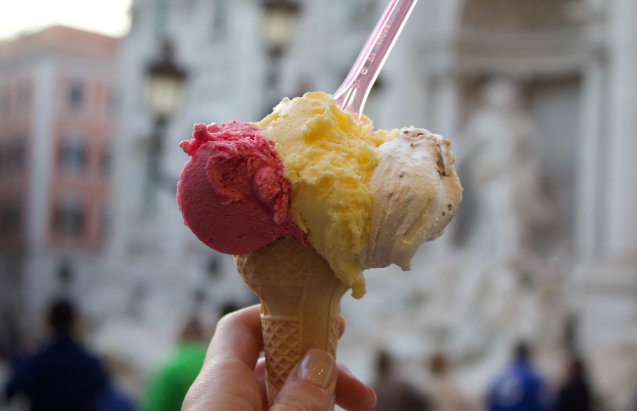 a hand holding a cone with a spoon in it