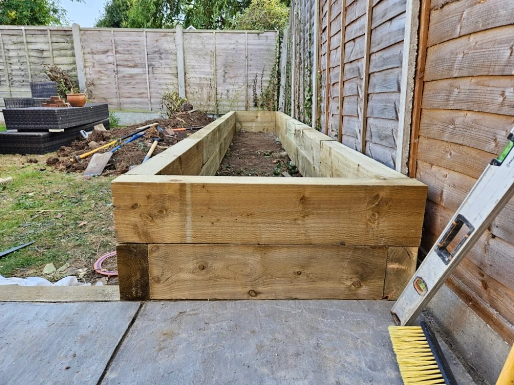 a wooden planter box in a backyard