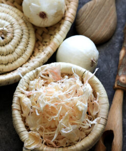 a group of baskets with onions and a wooden spoon