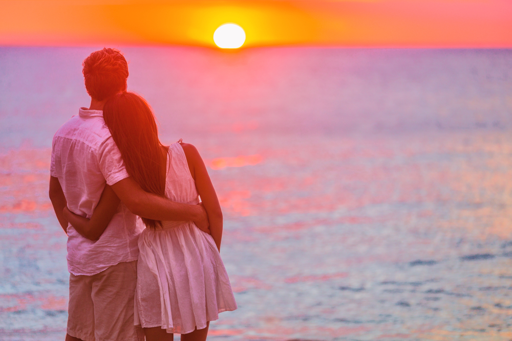 a man and woman hugging at the beach