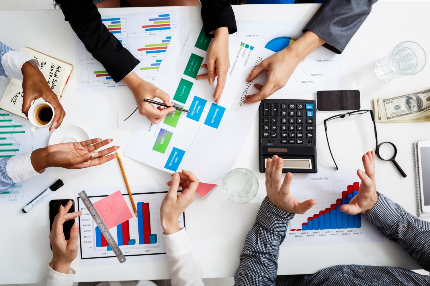 a group of people sitting around a table with papers and calculator