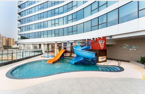 a pool with slide in front of a building