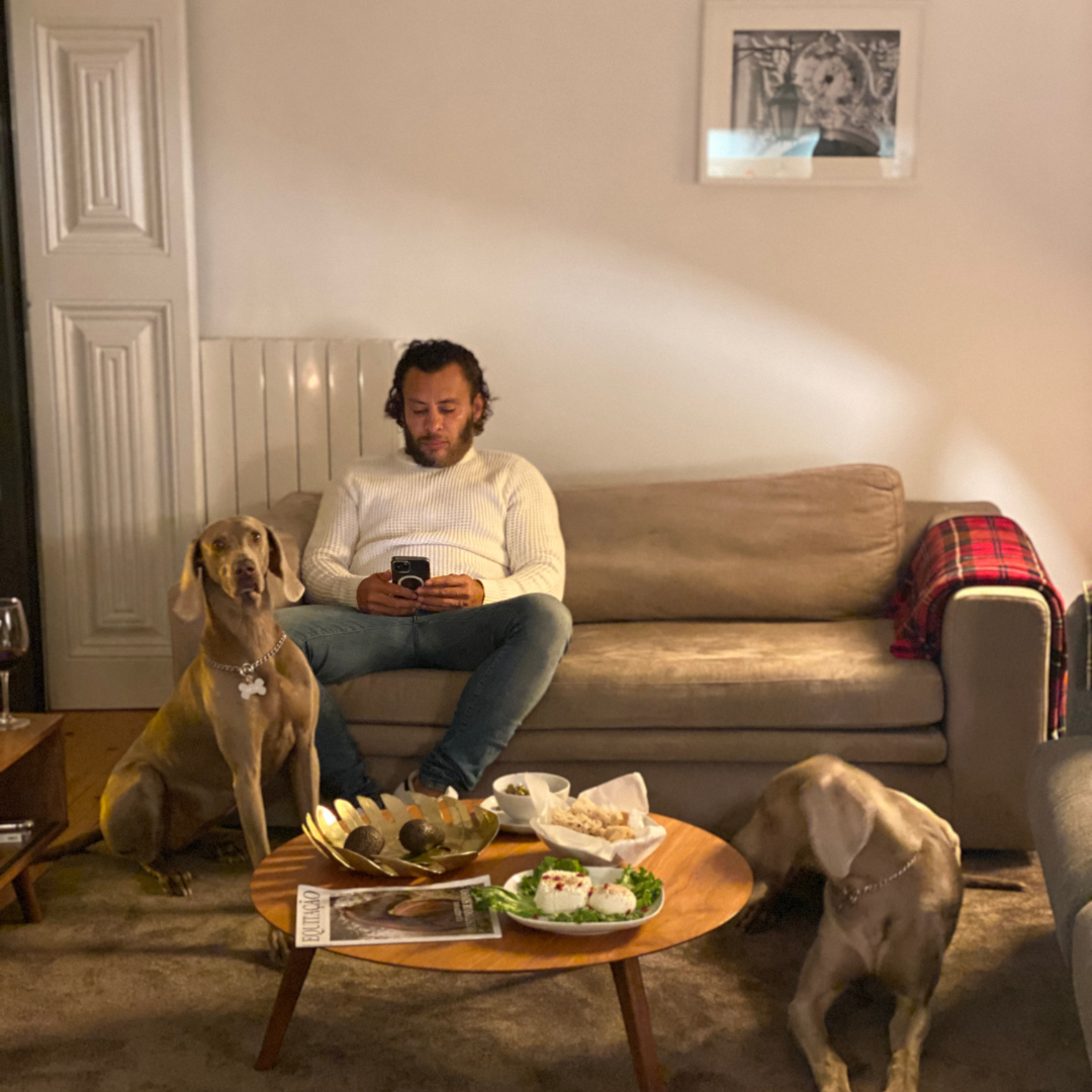 a man sitting on a couch with two dogs around him