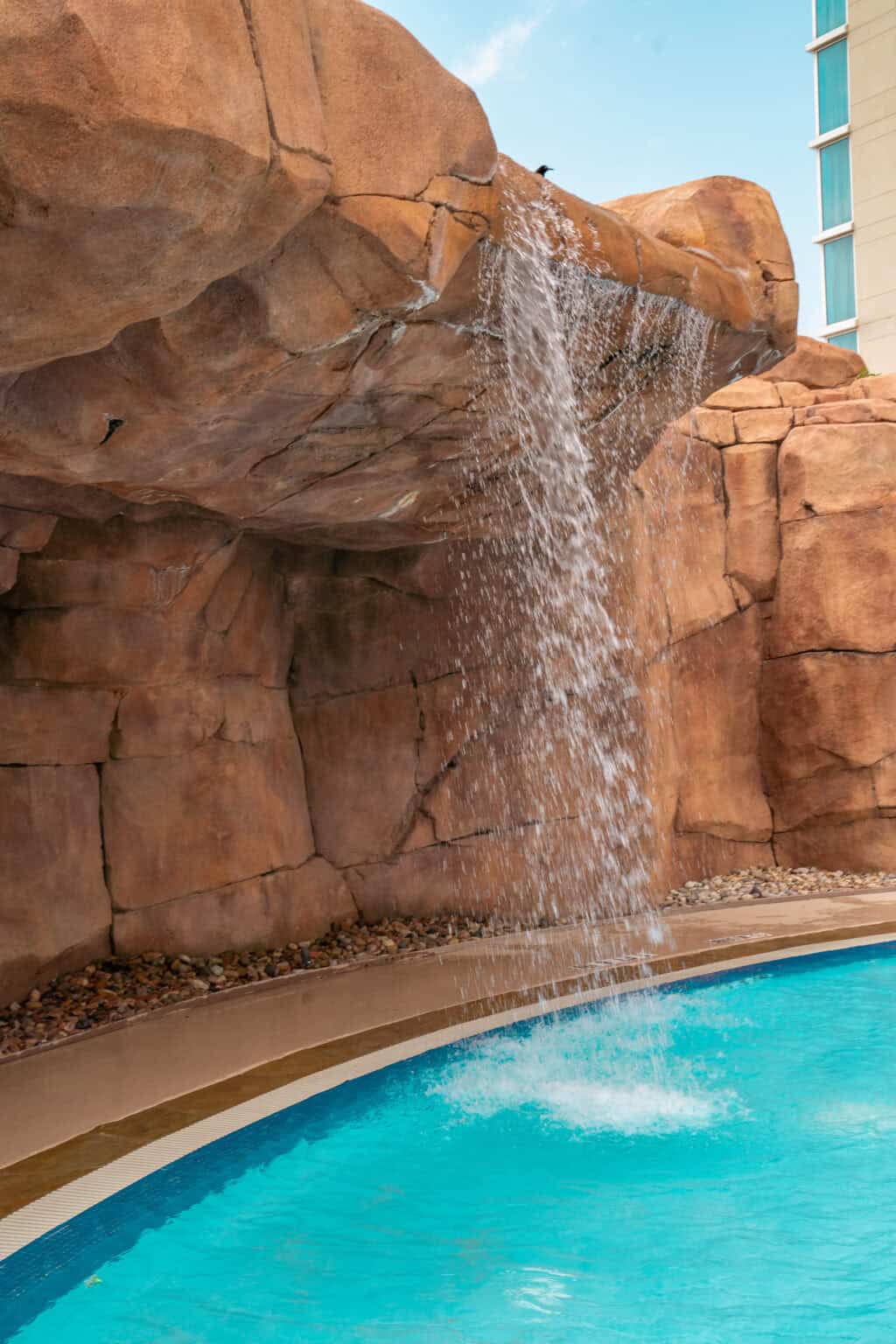 a waterfall over a pool