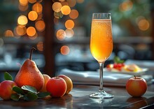 a glass of orange juice next to fruit