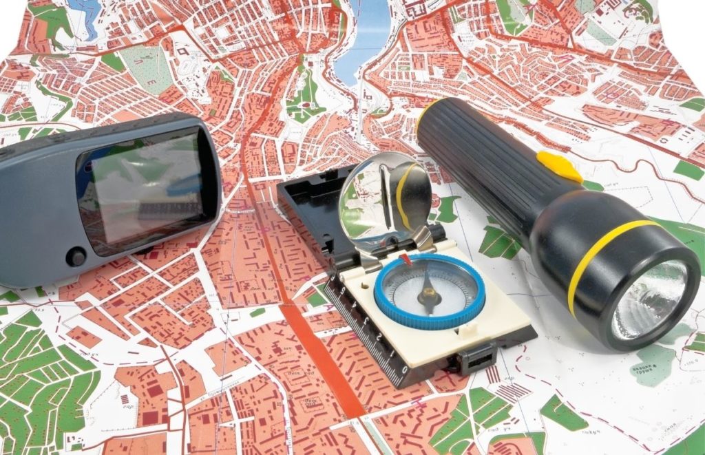 a compass and flashlight on a map