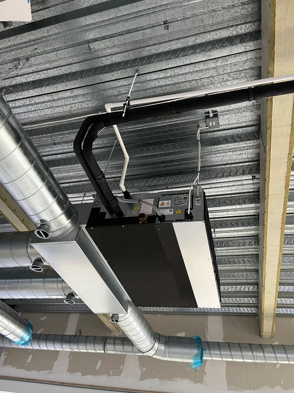 a metal pipes and a rectangular object on the ceiling