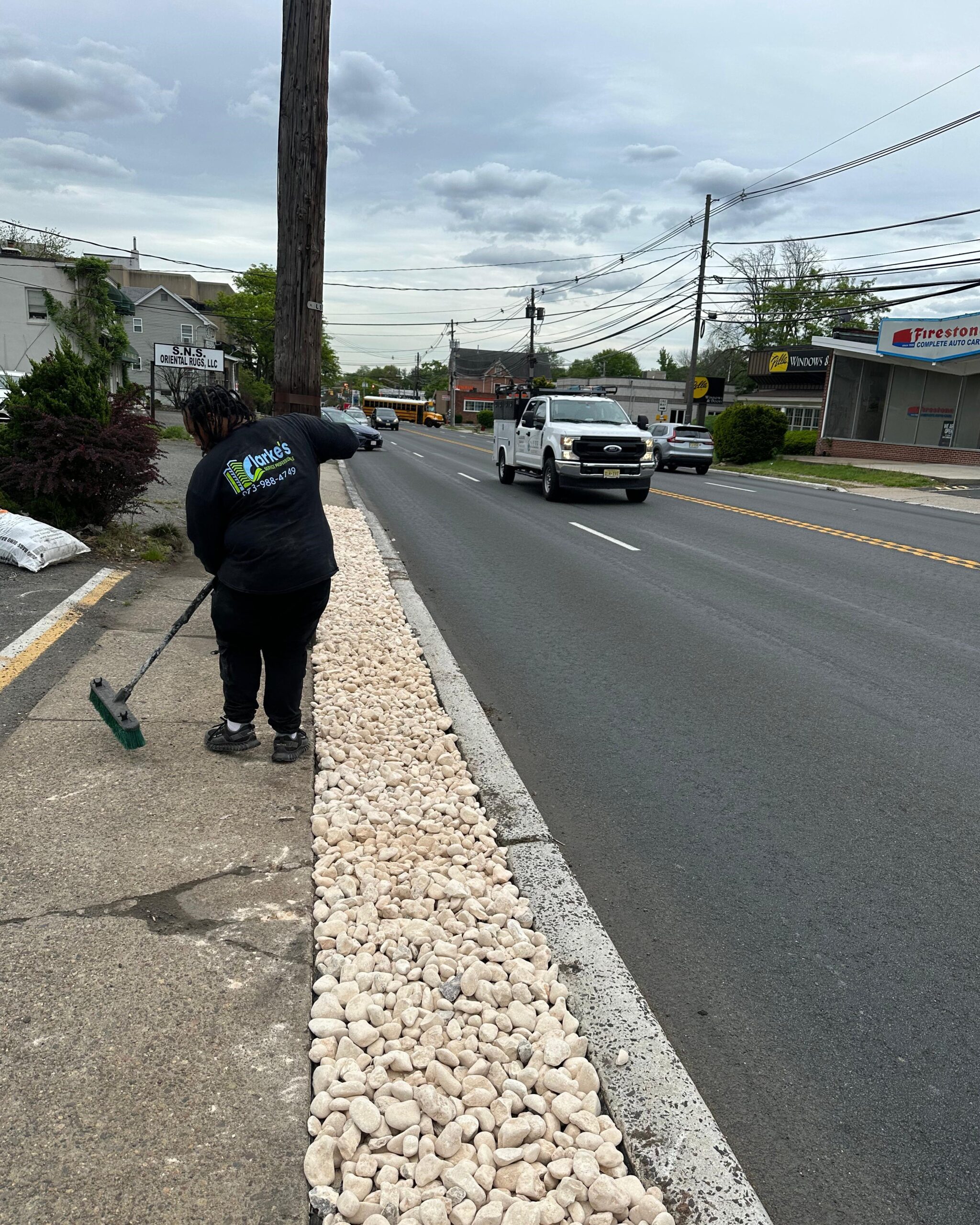 a person with a broom on the side of the road