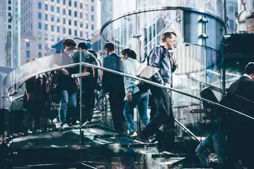 a group of people walking up a glass staircase