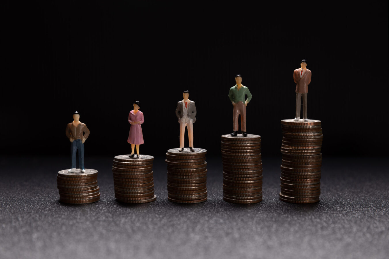 a group of miniature people standing on coins