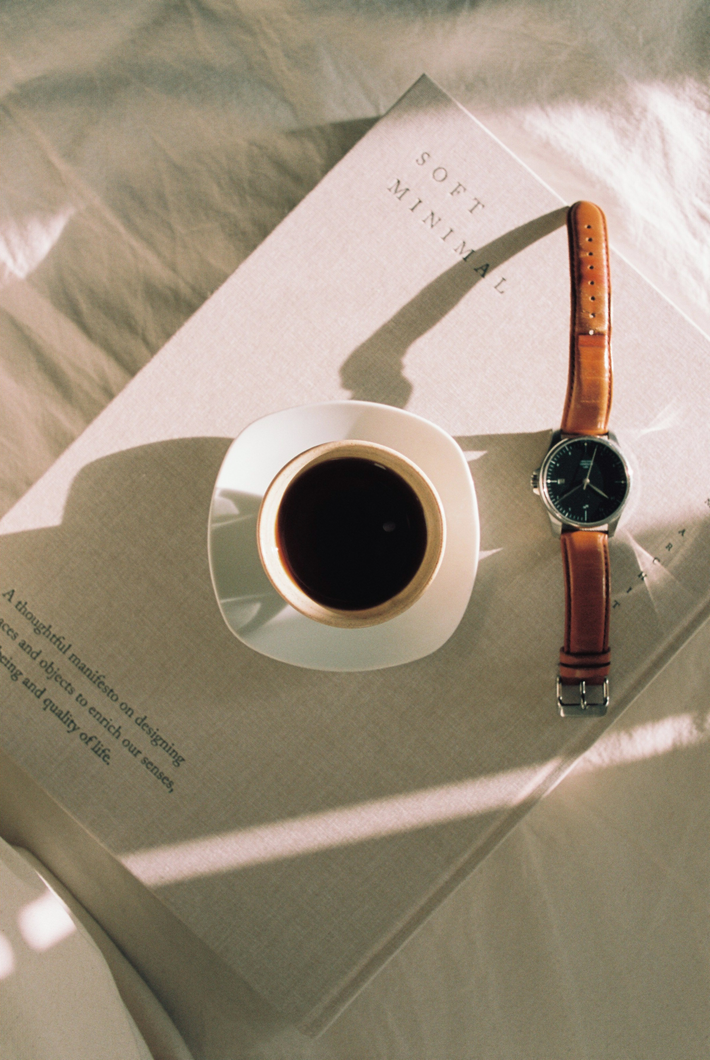 a cup of coffee and a watch on a book