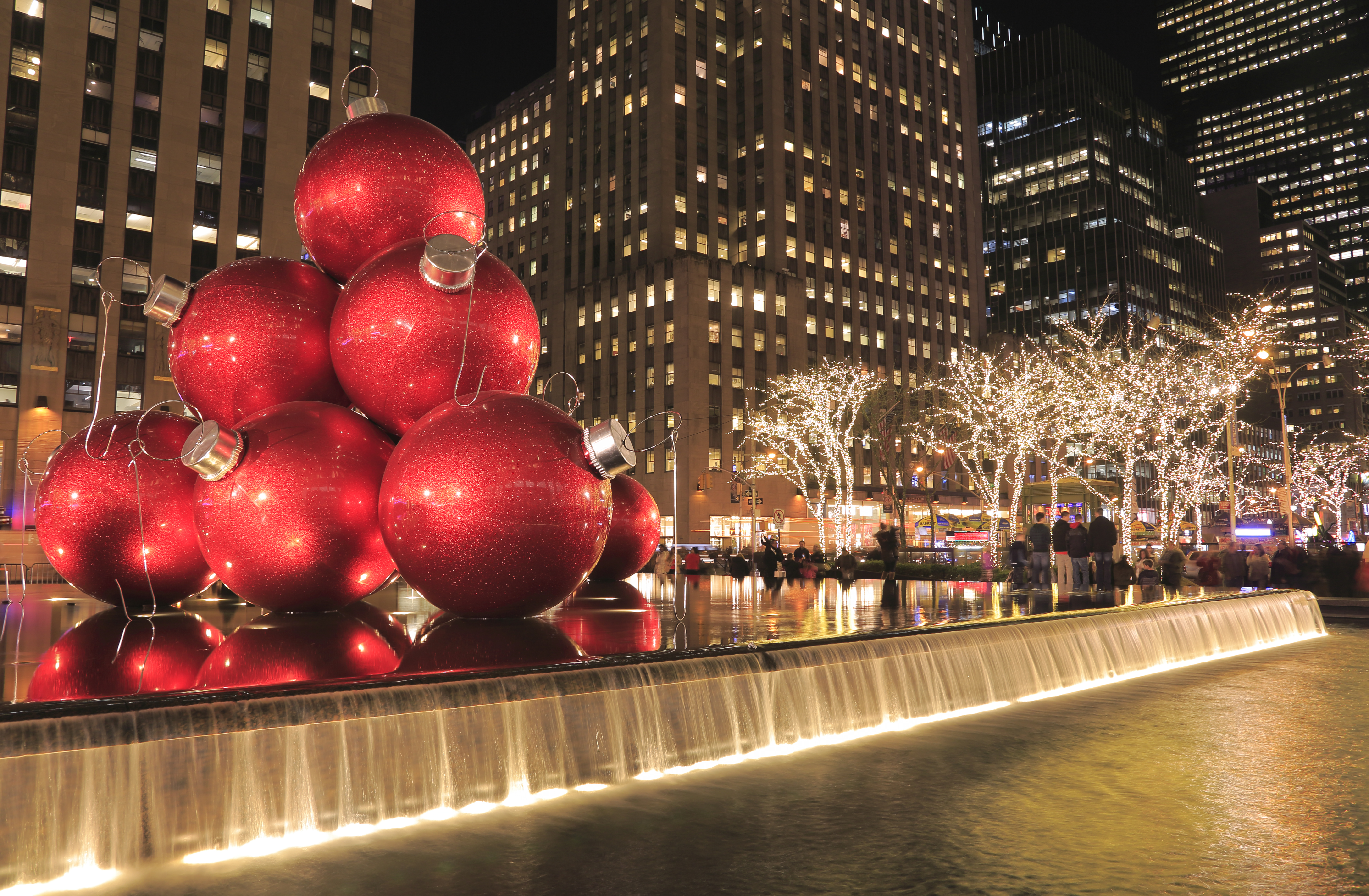 a large red ornaments on a fountain in front of buildings