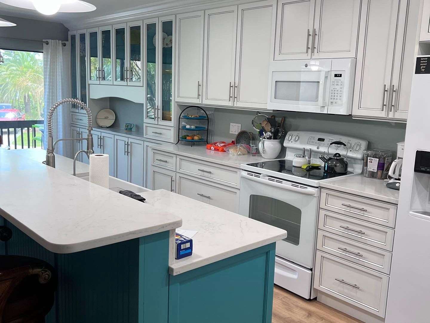 a kitchen with white cabinets and blue island
