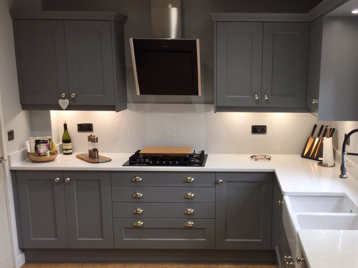 a kitchen with grey cabinets and white countertops