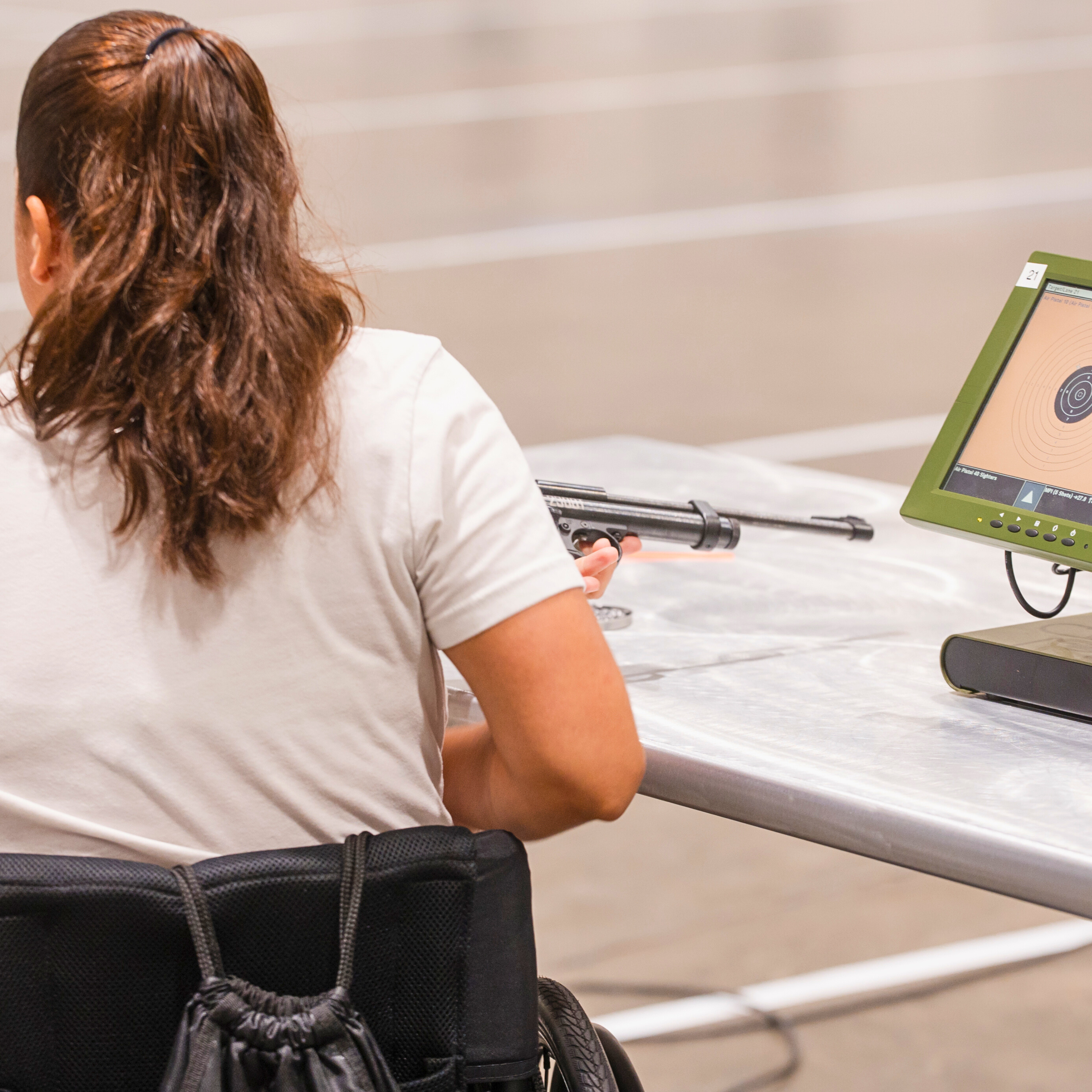 a woman sitting in a chair holding a gun