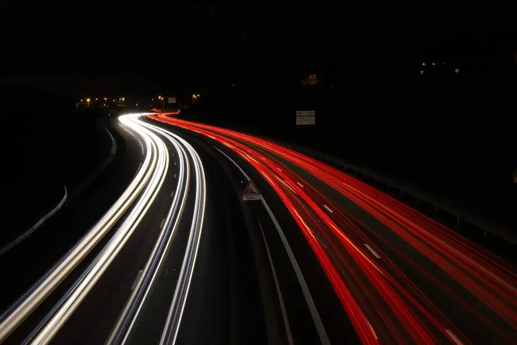 a red and white light streaks on a road