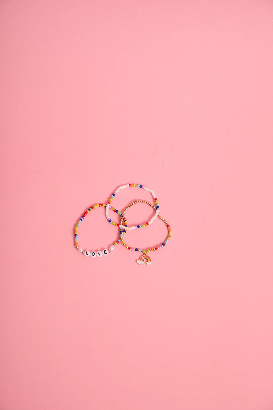 a group of bracelets on a pink background