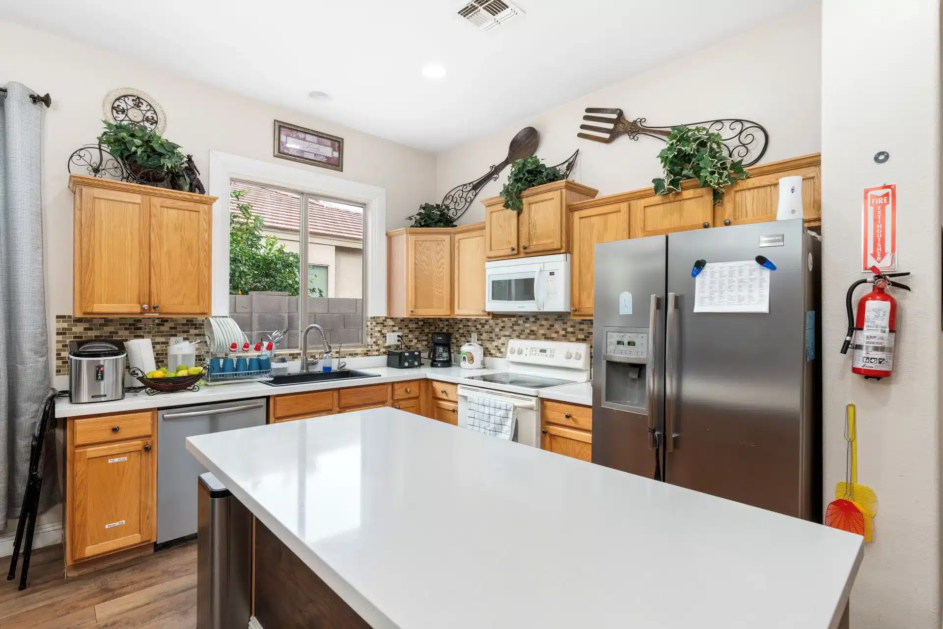 a kitchen with a large island and a stainless steel refrigerator