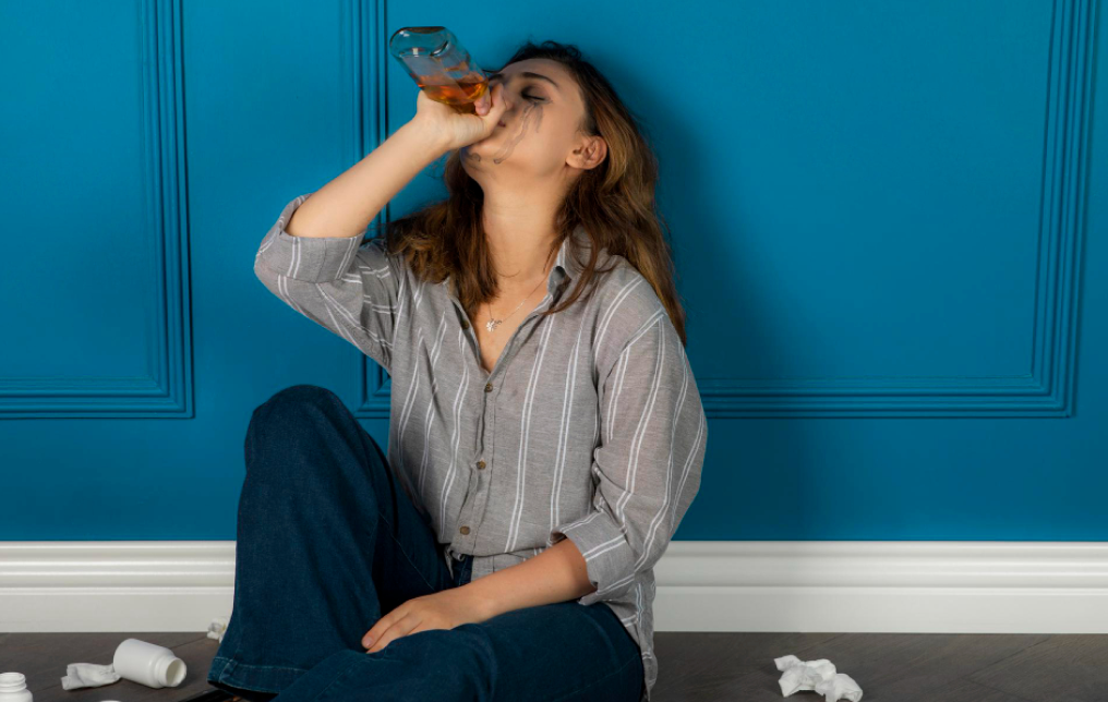 a woman drinking from a glass bottle