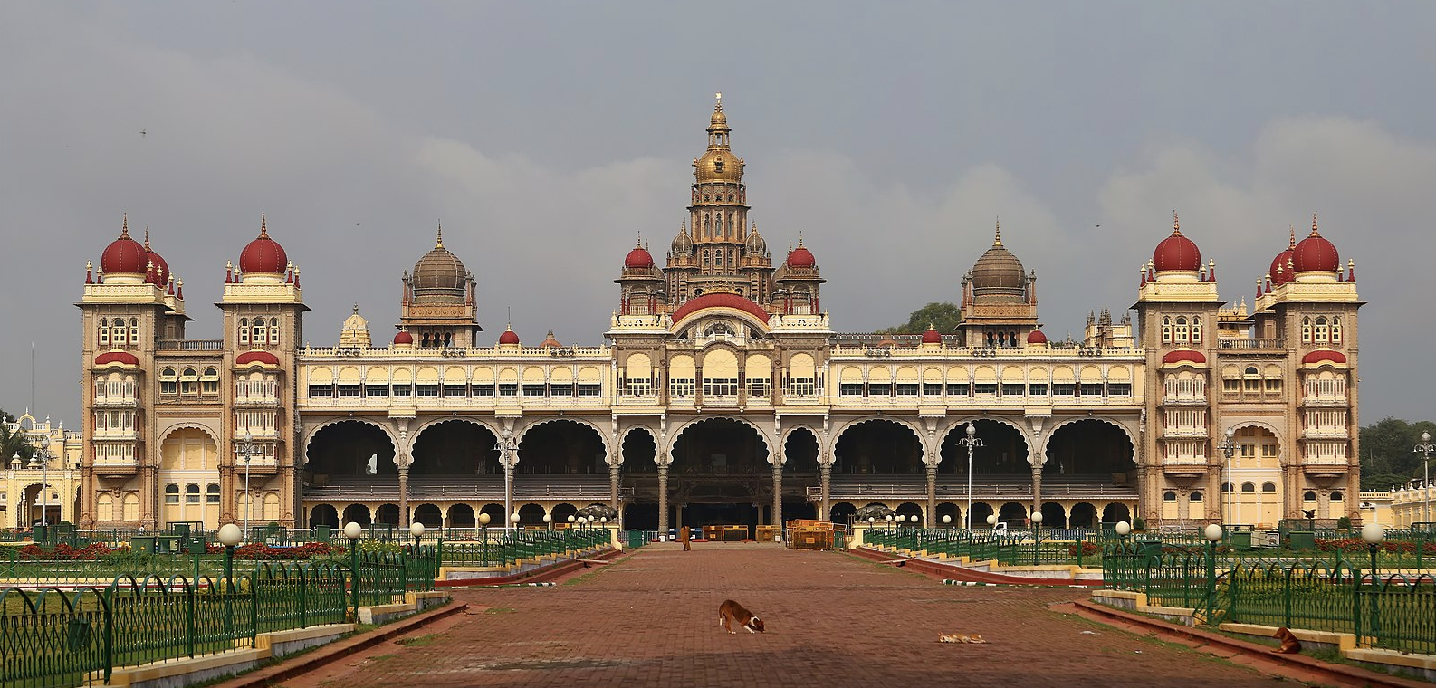 a large building with a large courtyard and a large building with a large tower with Mysore Palace in the background