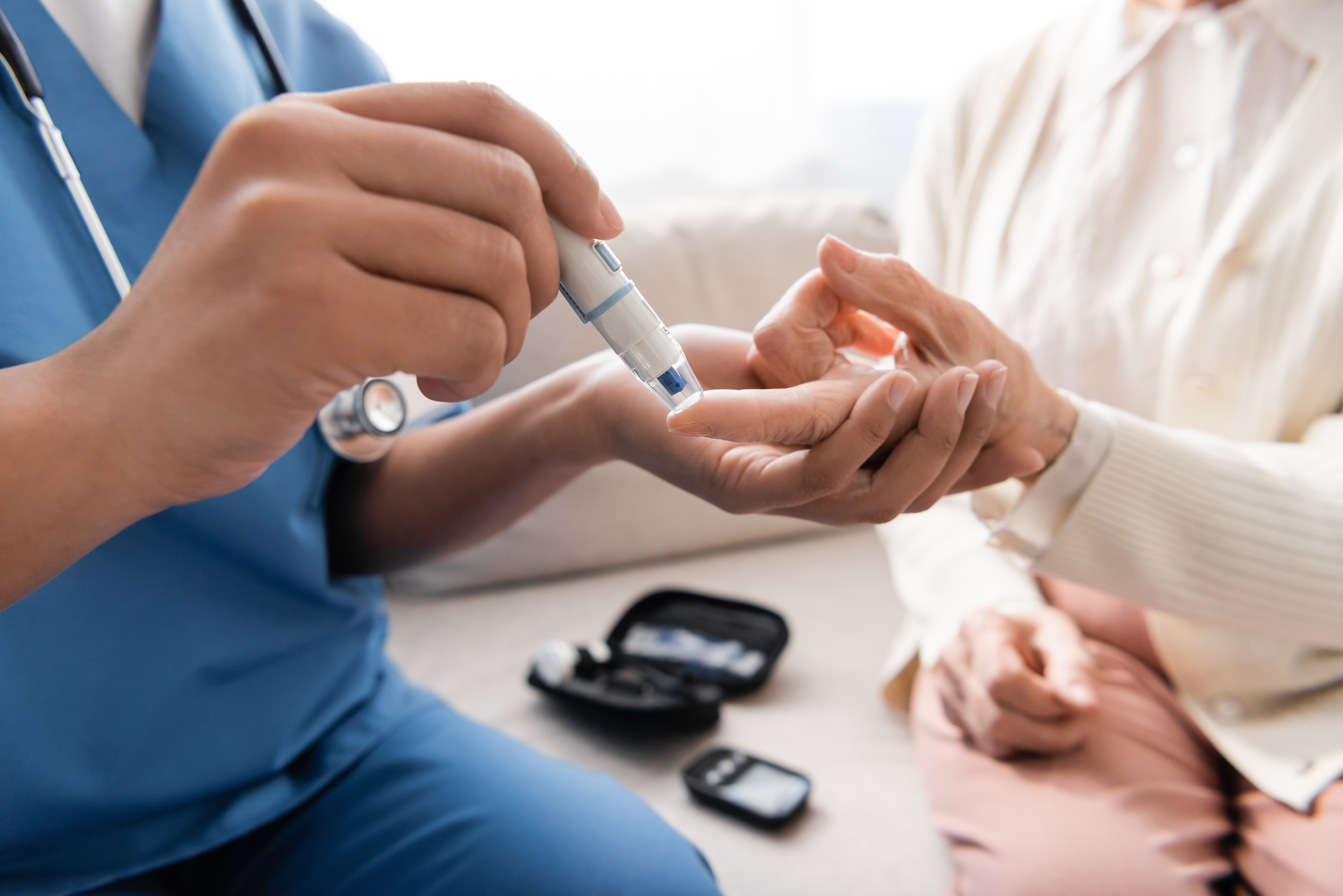 a doctor using a device to check the blood sugar level of a patient