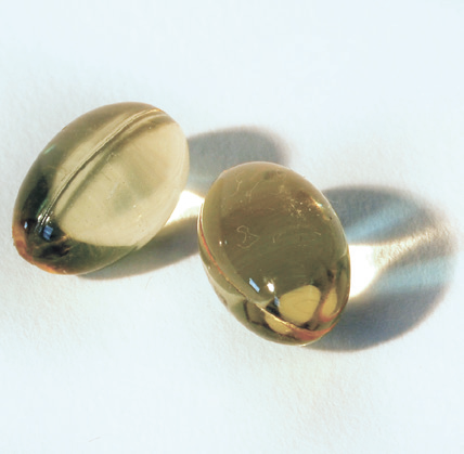 close-up of two pills on a white surface