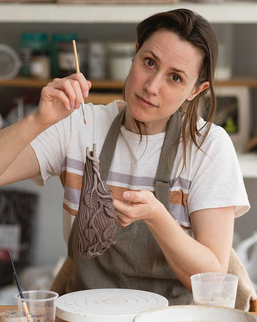 a woman painting a piece of fabric