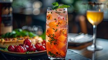 a glass of liquid with fruit on it