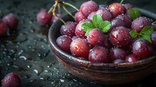 a bowl of grapes with leaves