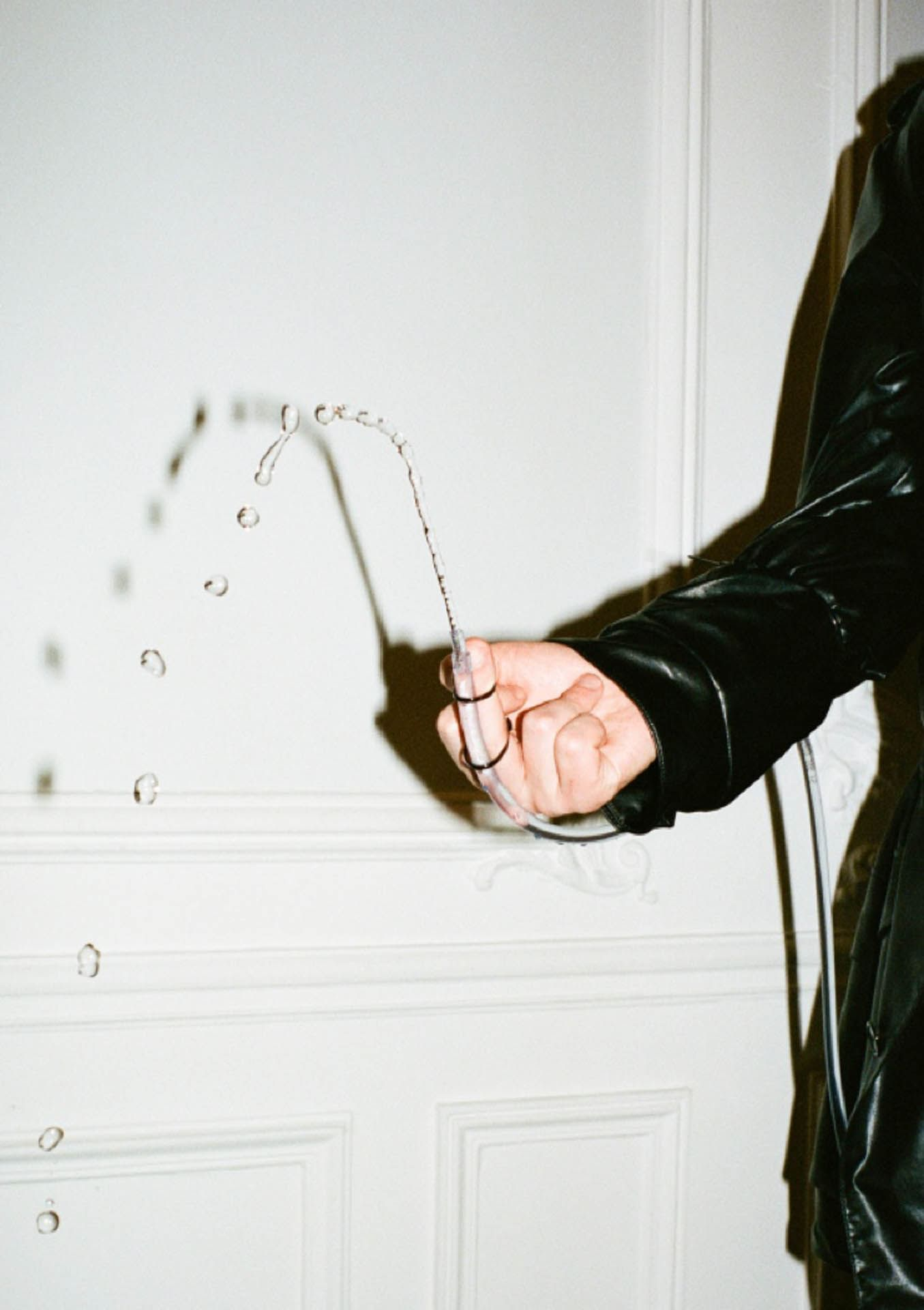 a person holding a hose with water drops