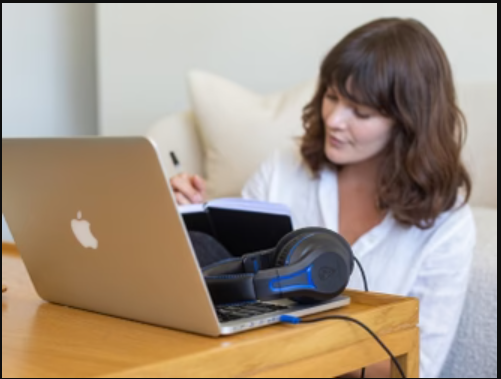 a woman sitting in a chair looking at a laptop