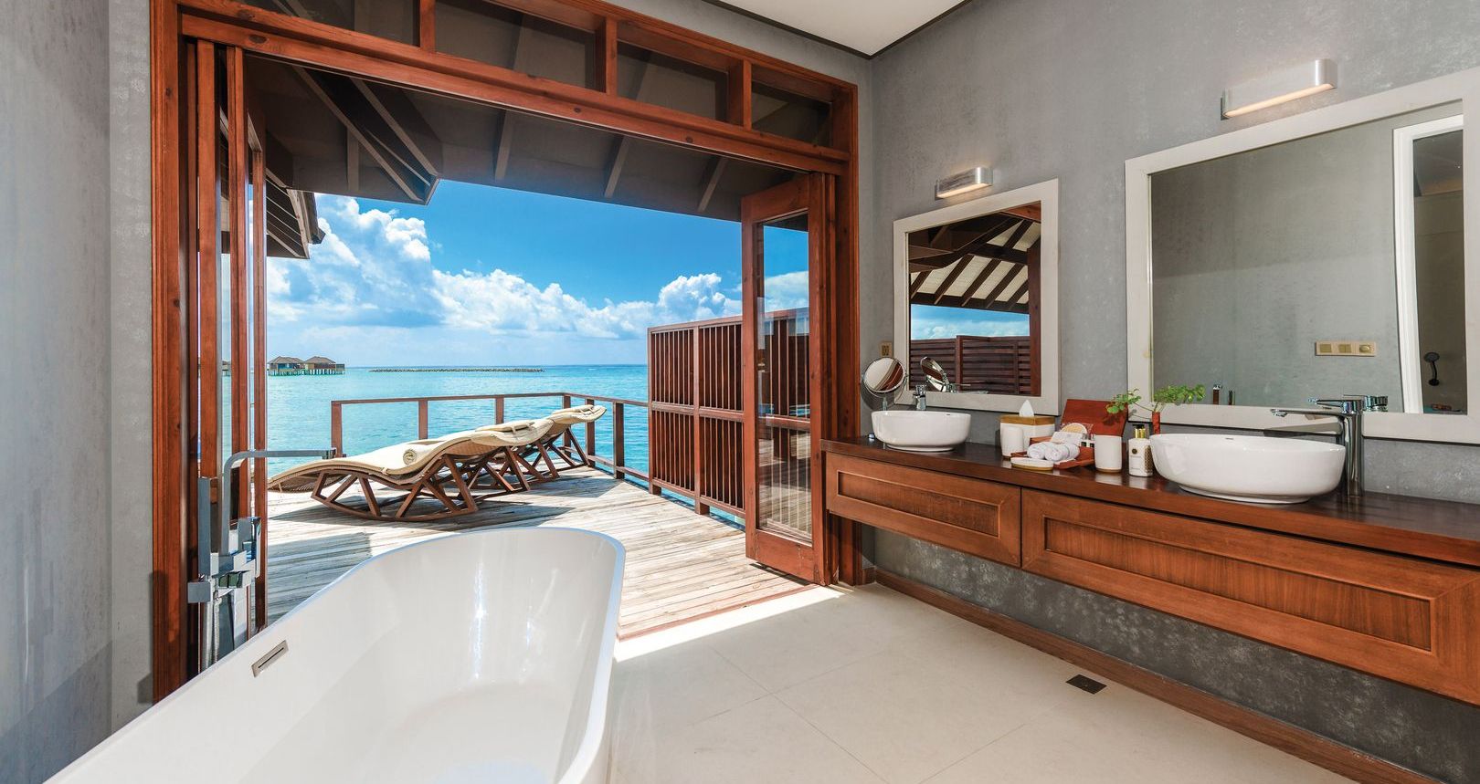 a bathroom with a bathtub and a bathtub on a deck overlooking the ocean