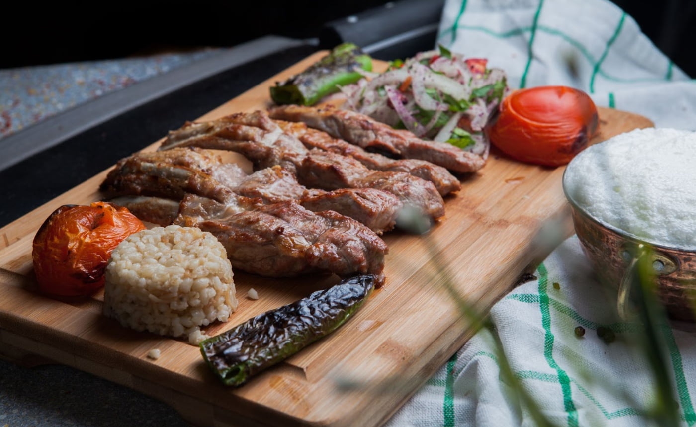 a wooden board with meat and vegetables