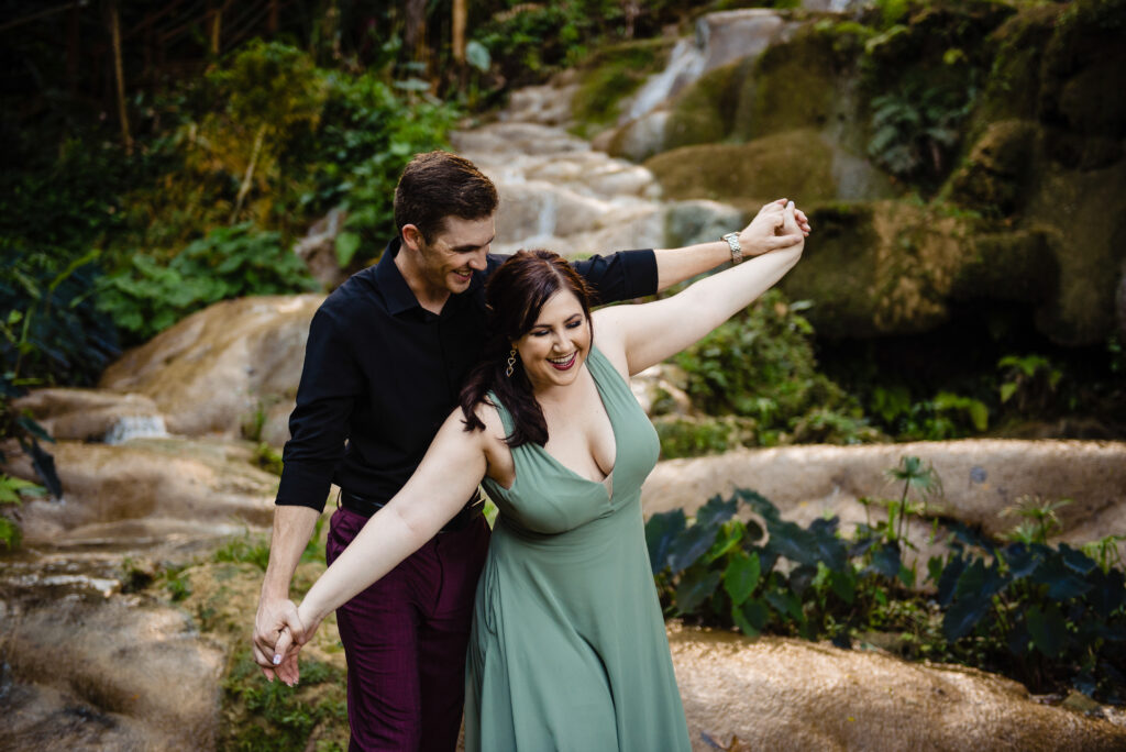 a man and woman holding hands and dancing in the woods