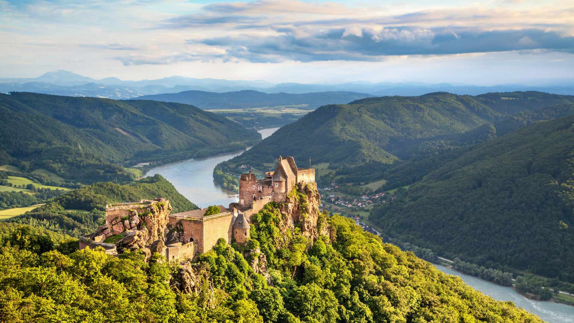 a castle on a cliff above a river