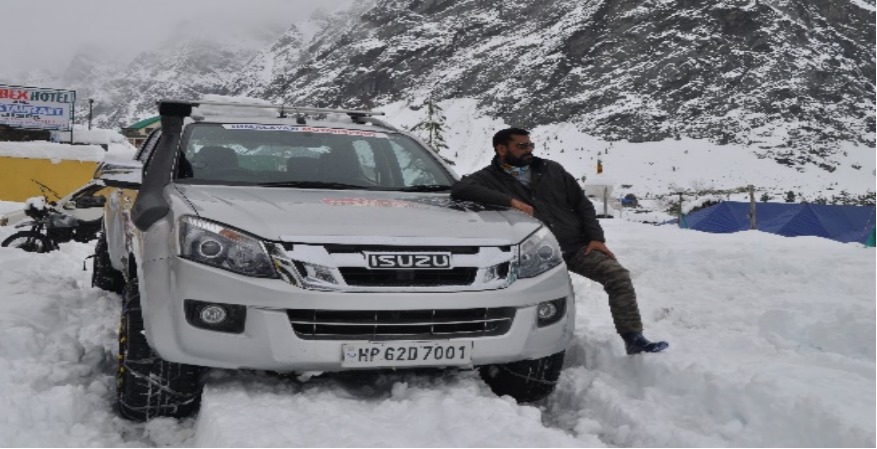 a man leaning on a car in the snow