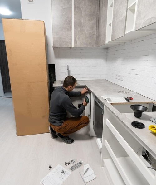 a man working on a dishwasher