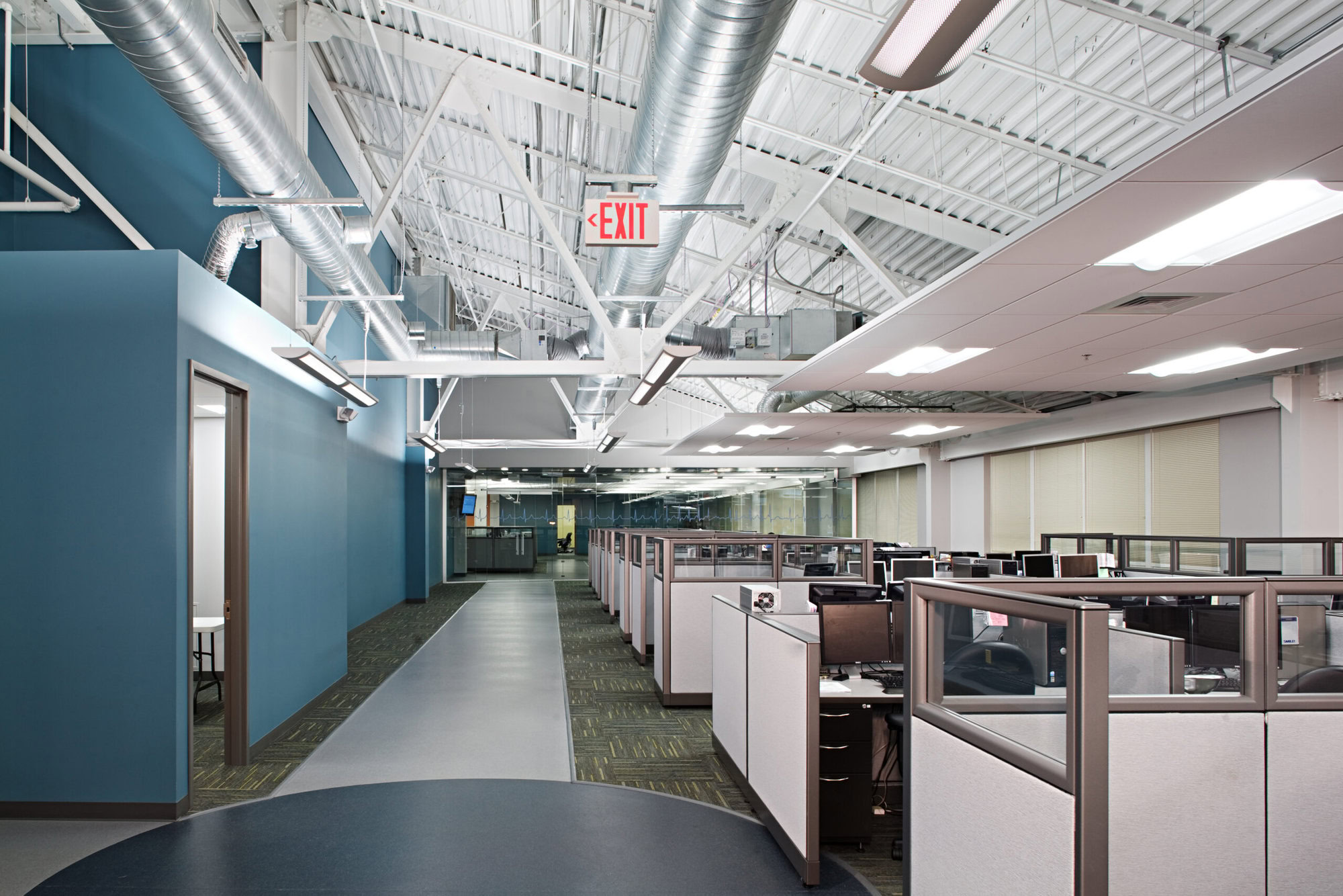 an office with cubicles and an exit sign